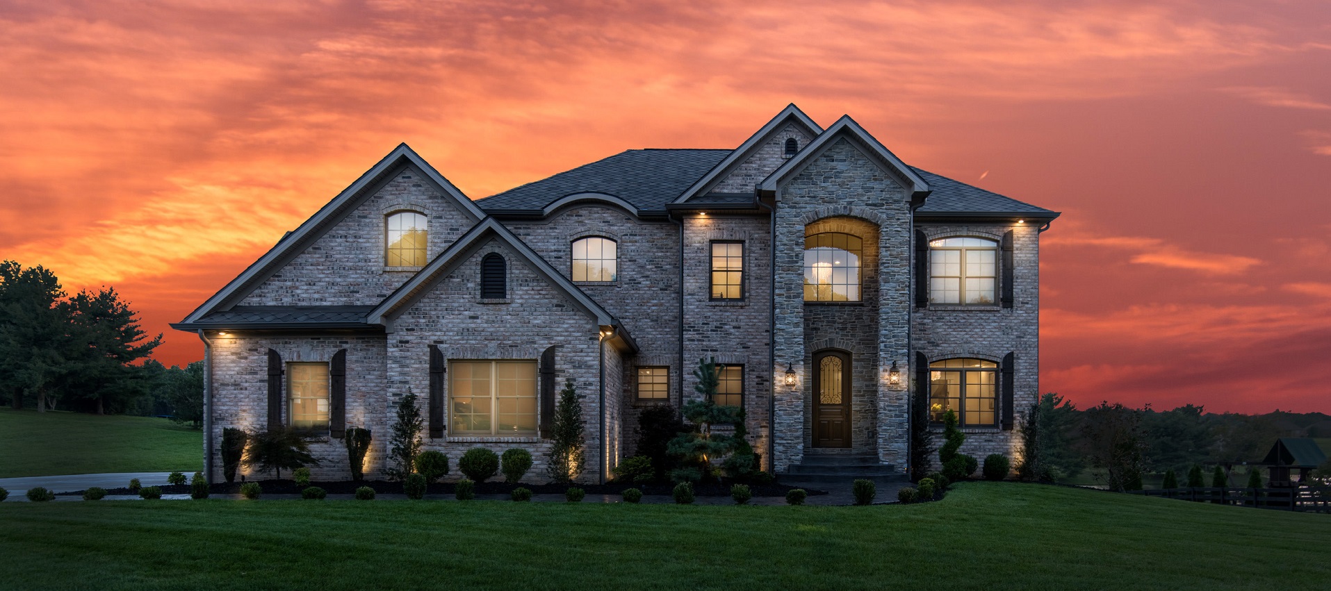 Stone custom home exterior at sunset